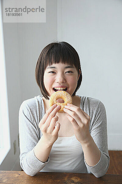 Junge Japanerin isst einen Donut