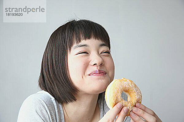 Junge Japanerin isst einen Donut