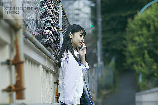 Japanisches Highschool-Mädchen telefoniert