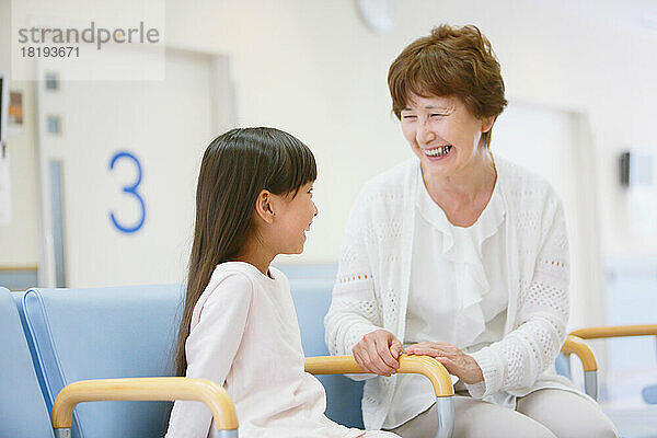 Japanische Seniorin und Enkelkind im Wartezimmer des Krankenhauses