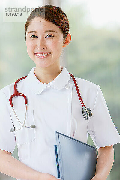 Lächelnde junge japanische Krankenschwester