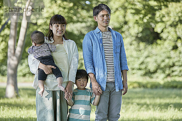 Frisches Grün und lächelnde japanische Familie