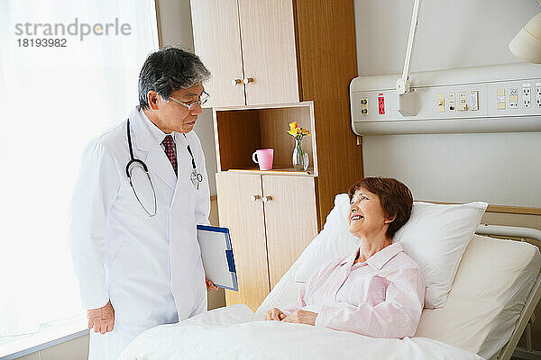 Ältere Frau wird von einem Arzt in einem Krankenzimmer untersucht