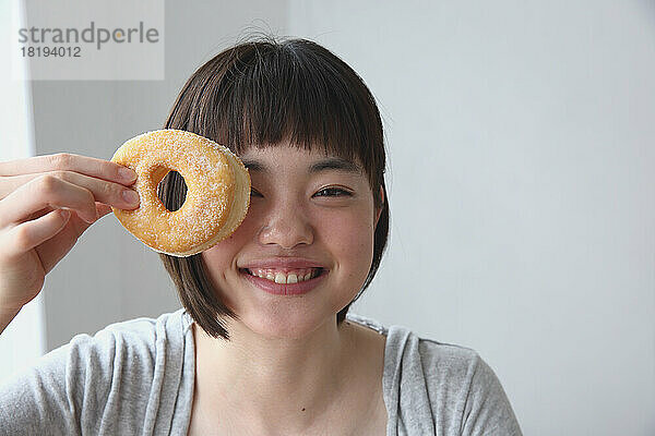 Junge Japanerin hält einen Donut