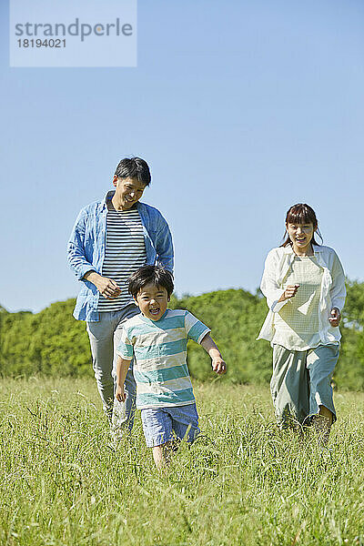 Japanische Familie läuft auf dem Feld