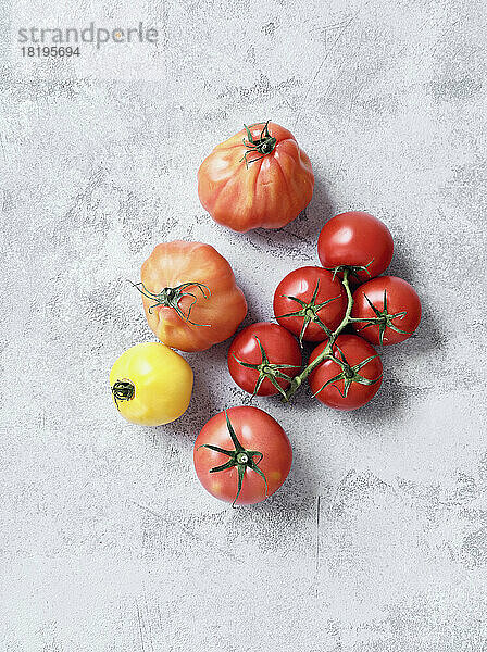 Stilleben Vielfalt rote und gelbe Tomaten auf grauem Hintergrund