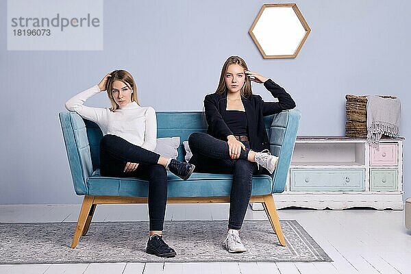 Zwei Mädchen sitzen zusammen auf dem Sofa. Freundschaft und Teenager Beziehungen