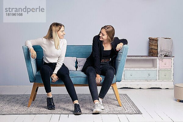 Zwei Mädchen unterhalten sich auf der Couch. Freundschaft und Teenager Beziehungen