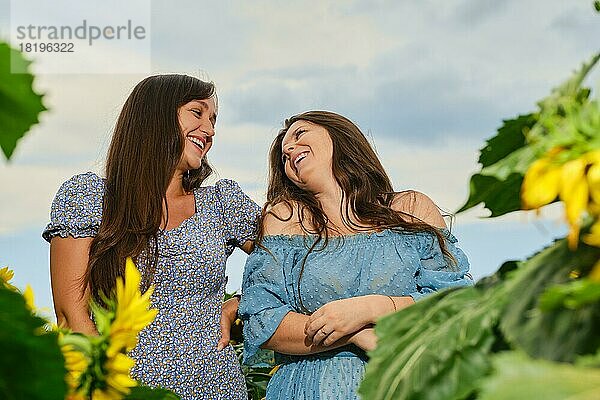 Zwei glückliche Frauen lachen auf einem Maisfeld
