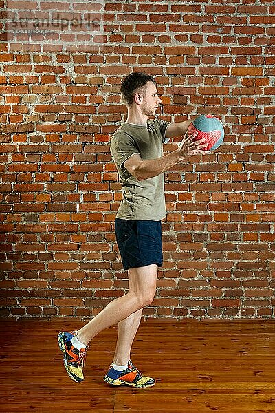Athletischer Mann macht Gleichgewichtsübungen mit Ball. Fitness-Workout