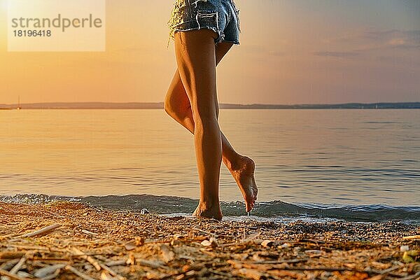 Cropped Bild der barfuß Frau zu Fuß entlang des Strandes in Sonnenuntergang Zeit