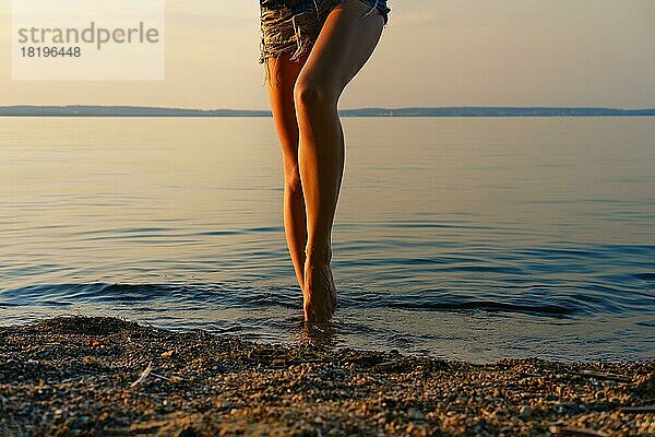 Cropped Bild der barfuß Frau immer aus dem Wasser am Strand in den Sonnenuntergang Zeit