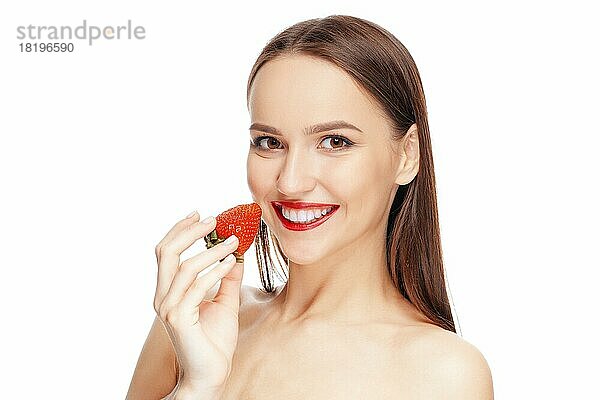 Schöne glückliche Mädchen mit sauberen und frischen Haut essen Erdbeere. Kosmetologie  Behandlung  Schönheit und Spa  Hautpflege und Aromatherapie