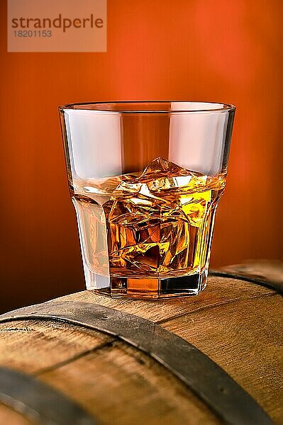 Glas Whisky mit Eis oben auf dem Fass (Weichzeichner mit geringer Schärfentiefe)