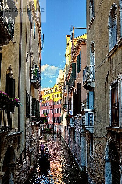 VENEDIG  ITALIEN  27. JUNI 2018: Enger Kanal zwischen bunten alten Häusern mit Gondelboot mit Touristen und Gonolier in Venedig  Italien  Europa