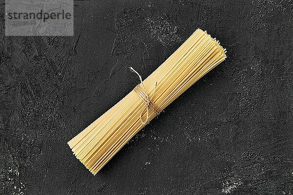 Draufsicht auf rohe Spaghetti auf schwarzem Hintergrund