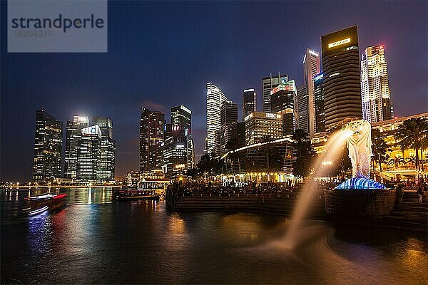SINGAPUR  1. JANUAR 2014: Nachtansicht des Singapur-Merlion an der Marina Bay vor der Skyline von Singapur. Der Merlion ist eine bekannte touristische Ikone  Maskottchen und nationale Personifikation von Singapur