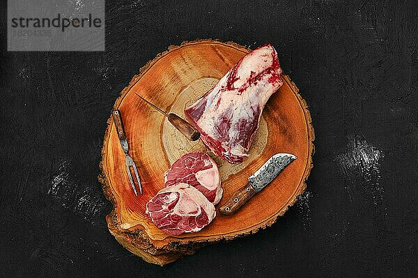 Zerlegen von Ossobuco-Steak aus Rinderhaxe mit Hackbeil auf Holzstumpf  Ansicht von oben