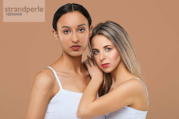 Schöne kaukasische und afrikanische junge Frauen mit unterschiedlichen Hauttypen