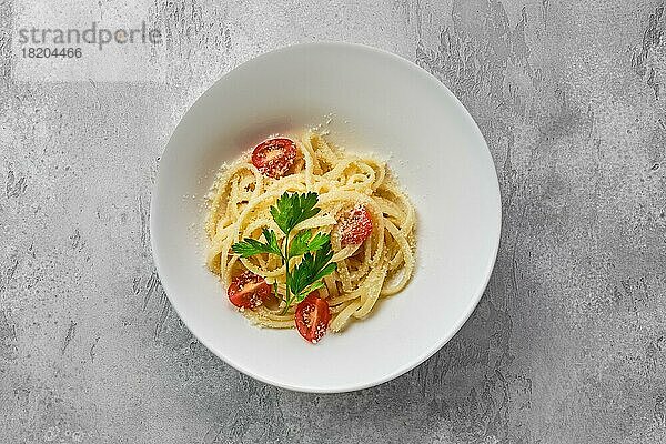 Draufsicht auf den Teller mit Nudeln mit Parmesan und Tomate