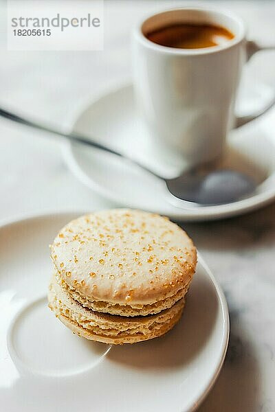 Foto mit geringer Schärfentiefe von Macaron mit gesalzenem Karamell auf einer weißen Untertasse