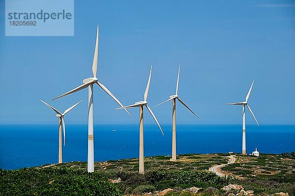 Grüne erneuerbare alternative Energie Konzept  Windgenerator Turbinen erzeugen Strom. Windpark auf der Insel Kreta  Griechenland mit kleiner weißer Kirche