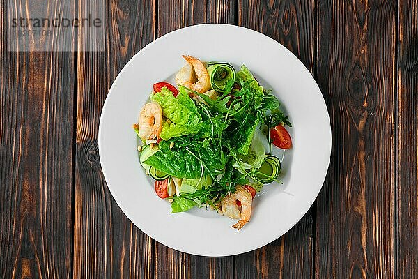 Draufsicht auf Salat mit Garnelen  Tintenfisch  Gurke  Tomate und Pinienkernen