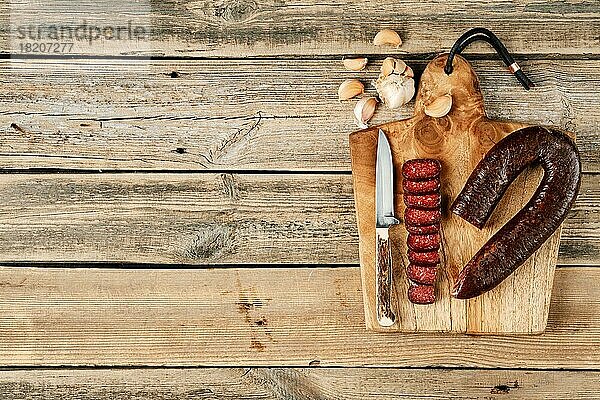 Draufsicht auf geräucherte  getrocknete Rindfleischwurst auf einem Holzschneidebrett
