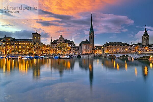 Ortsansicht der beleuchteten Altstadt Zürich nach Sonnenuntergang  Spiegelung der Kirchen Fraumünster und St. Peter im Fluss Limmat