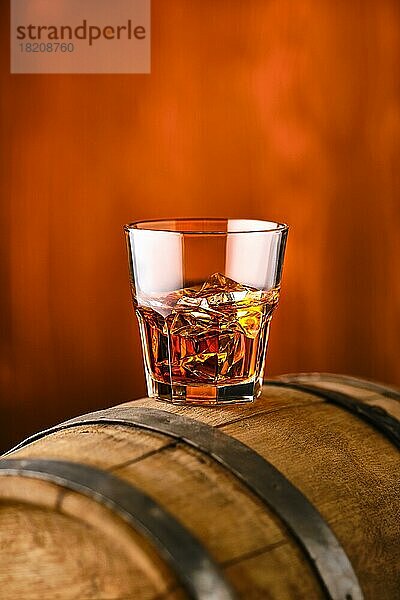 Glas Whisky mit Eis oben auf dem Fass (Weichzeichner mit geringer Schärfentiefe)