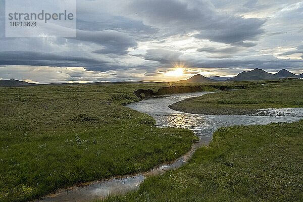 Sonnenuntergang zwischen Wolken  Fluss fliest durch Wiesen  Möðrudalur  isländisches Hochland  Island  Europa