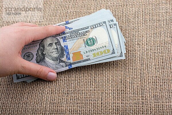 Hand hält Banknote Bündel von US-Dollar auf einem Leinen Leinwand Hintergrund