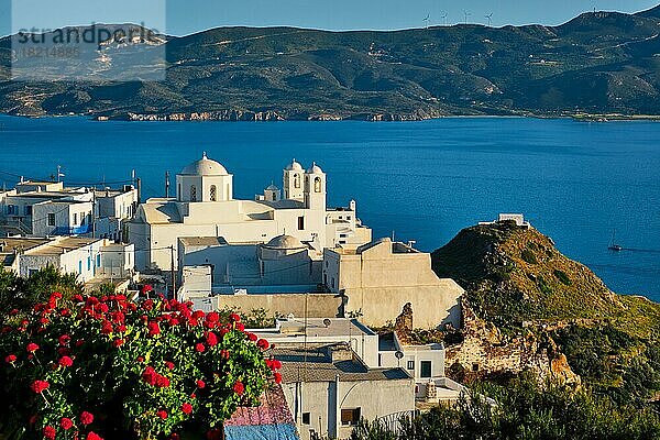 Malerischer Blick auf die griechische Stadt Plaka auf der Insel Milos über rote Geranienblüten und die orthodoxe griechische Kirche. Plaka Dorf  Milos Insel  Griechenland  Europa