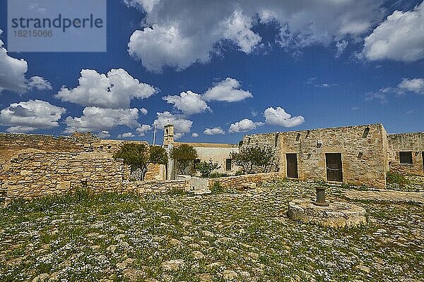 Aptera  Archäologische Stätte  Ausgrabungsstätte  römisch  dorisch  mykenisch  Stadtstaat  Kloster Agios Ioannis Theologos  gepflasterter Innenhof  Frühlingsblumen auf dem Pflaster  KIrche  Brunnen  blauer Himmel mit weißen Wolken  Souda-Bucht  Souda  Chania  Westkreta  Insel Kreta  Griechenland  Europa