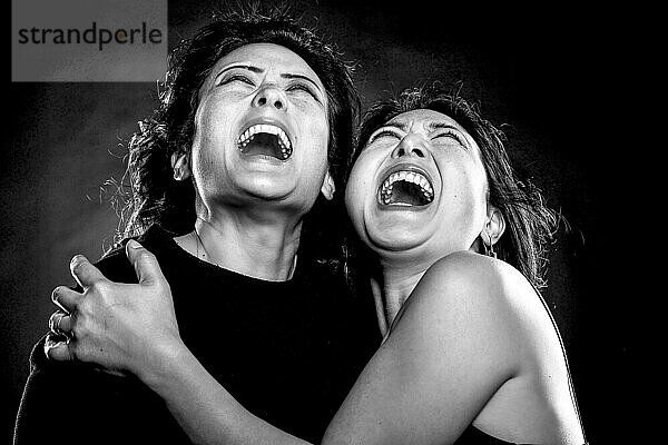 Zwei asiatische Frauen  Schwestern  koreanische Geschwister  Umarmung  Schrei  offener Mund  Schwarz-Weiß-Aufnahme