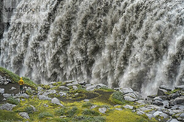 Tourist steht an einem Canyon  Canyon mit herabstürzenden Wassermassen  Dettifoss  Wasserfall im Sommer  Nordisland  Island  Europa