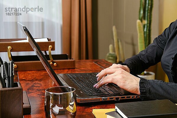 Unbekannte Frau tippt auf der Tastatur eines Laptops
