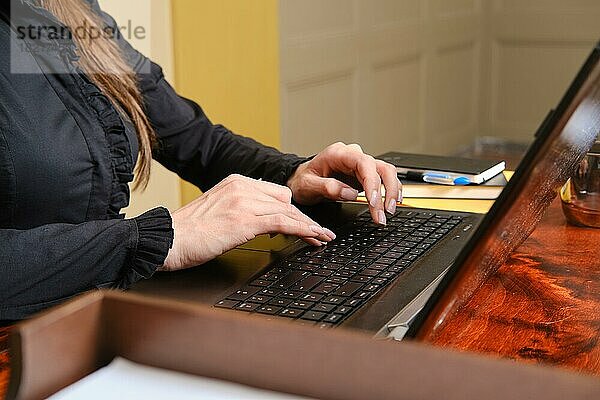 Unbekannte Frau tippt auf der Tastatur eines Laptops