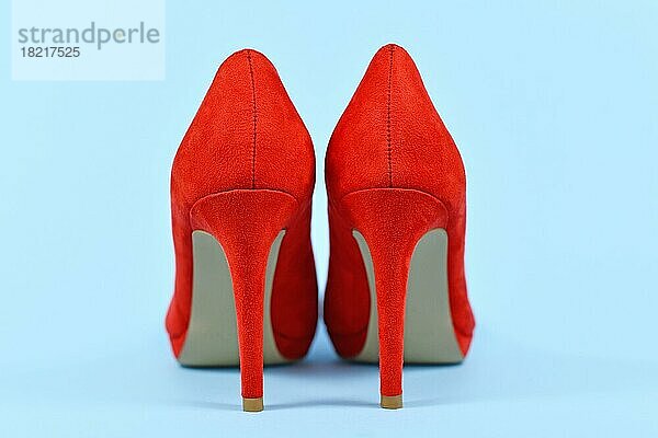 Rückansicht der eleganten roten synthetischen Wildleder Leder High Heel Frau Schuhe auf blauem Hintergrund