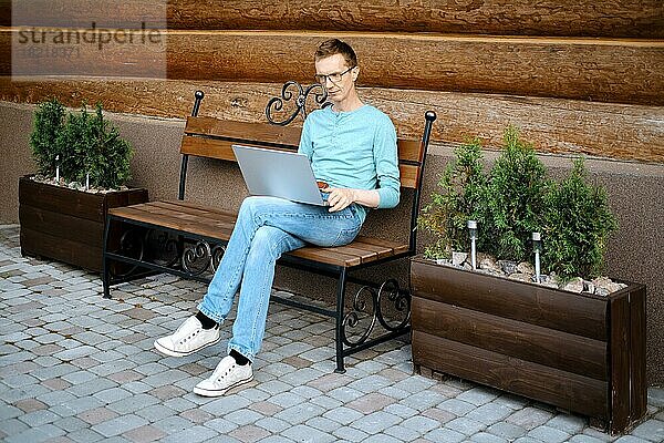 Mann mittleren Alters tätigt Online-Bestellung mit Laptop im Freien
