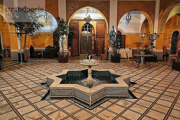 Beleuchteter Innenhof mit verziertem sternförmigem Brunnen in einem Riad  Inneneinrichtung im marokkanischen Stil  Hotel Palais Didi  Meknès  Marokko  Afrika