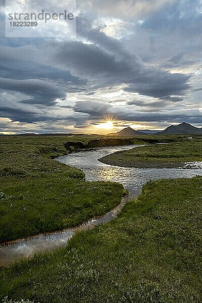 Sonnenuntergang zwischen Wolken  Fluss fliest durch Wiesen  Möðrudalur  isländisches Hochland  Island  Europa