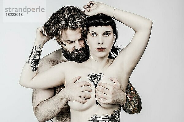 Nacktes junges Paar mit Tattoos