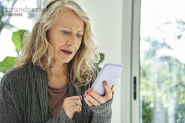 Ältere Frau überprüft E-Mail-Posteingang auf Smartphone