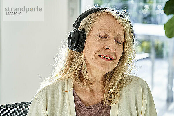 Senior woman enjoying listening to music on headphones