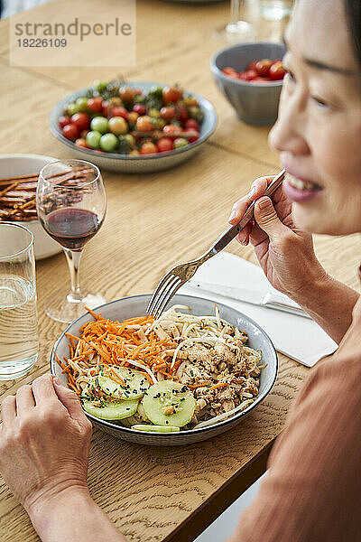 Seitenansicht einer asiatisch-amerikanischen Frau beim Essen mit Freunden