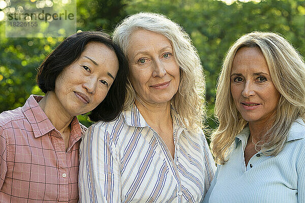 Gruppe von drei Frauen mittleren Alters posieren für ein Foto im Hinterhof