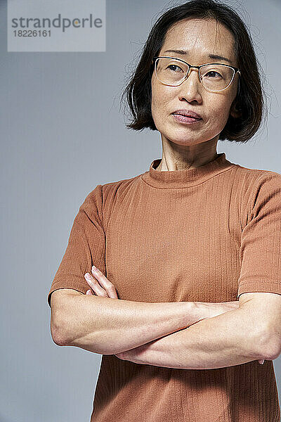 Mature Asian American woman with arms crossed