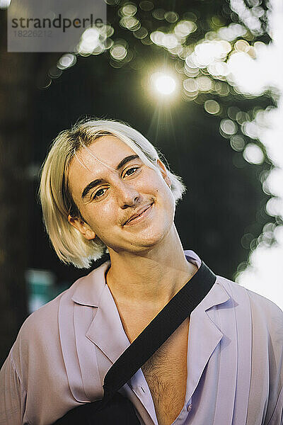 Porträt einer lächelnden nicht-binären Person mit blondem Haar