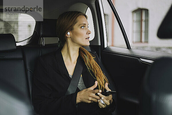 Geschäftsfrau mit braunem Haar sitzt im Auto